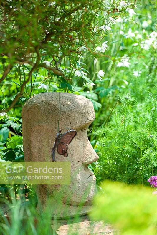 Sheila White's garden, Queens Gate, Bristol, UK. 'Easter Island' 'head' sculpture