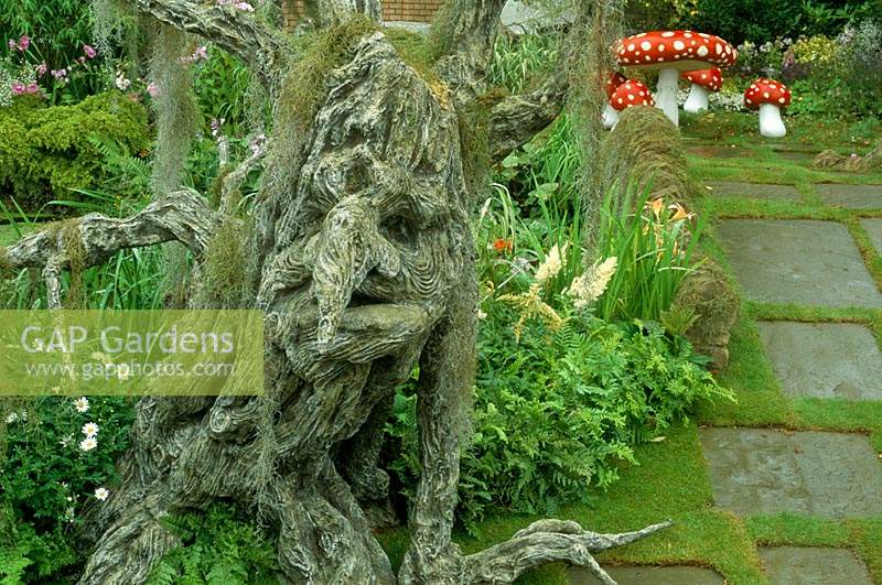 Hampton Court FS 1992 Children s fantasy garden with knarled tree troll with face Fairy mushroom seats and table