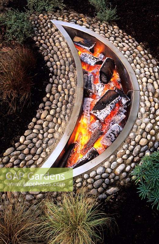 private garden Hampshire design Pamela Woods crescent moon shaped fire pit with pebbles