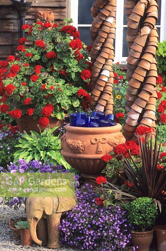Whichford Pottery Warwickshire terra cotta containers with red Pelargoniums Nemesia and Lobelia
