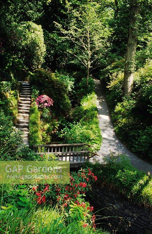 Bodnant North Wales path and steps leading down sloping garden to bridge over stream and water cascades