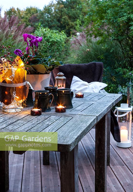 Garden furniture on terrace, set up with candles and mugs, Le Mas de BÃ©ty, France. 