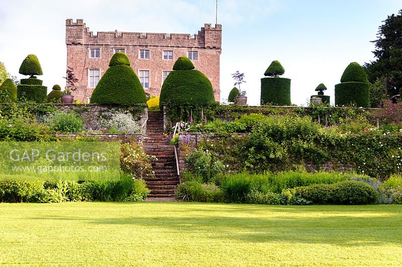 Ancient clipped yew topiary dominates the sequence of terraces between upper and lower gardens, Askham Hall, near Penrith, Cumbria. 