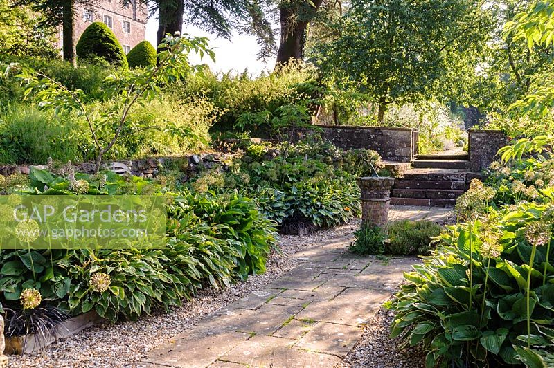 Sunken garden with central sundial and beds of hostas and alliums, Askham Hall,  Penrith, Cumbria, UK