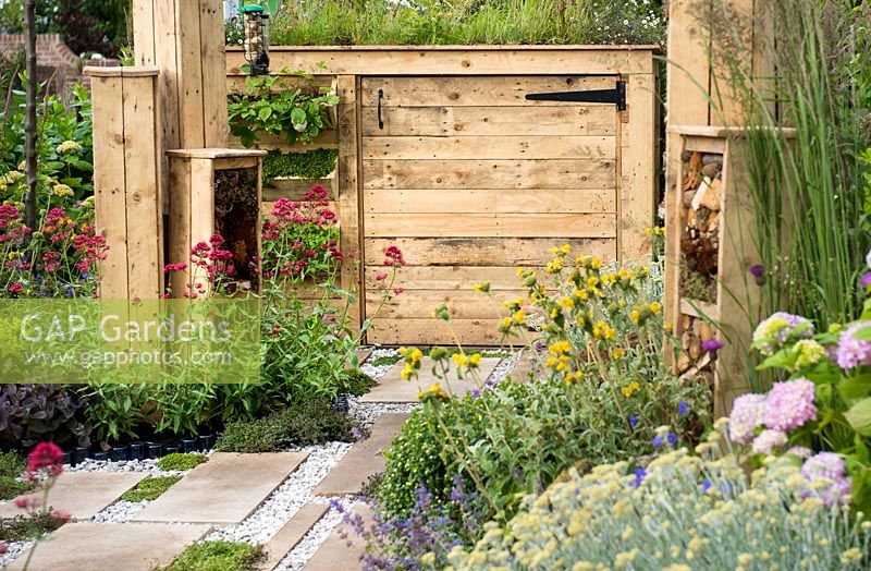 Bin storage made with recycled wood with green roof and pockets planted with wild strawberries Fragaria vesca and herbs - BBC Gardener's World Live, Birmingham 2017 - Artemis Landscapes Living in Sync Garden