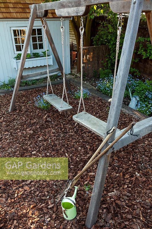 A view of a double wooden swing set.
