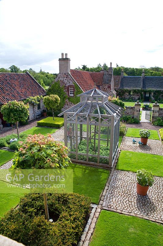 View of courtyard garden with central glasshouse. 