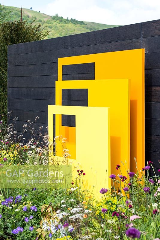 Yellow steel sculptural panels with black fence background - 'Urban Oasis', RHS Malvern Spring Festival 2018.