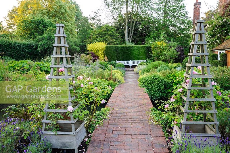 Double wooden obelisks in herb garden, Dipley Mill, Hartley Wintney, Hants, UK. 