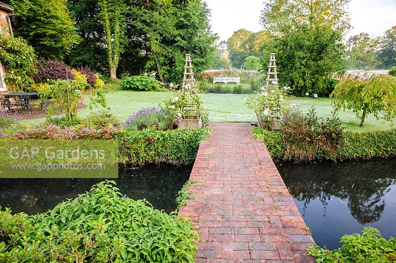 View across garden steam to lawn, Dipley Mill, Hartley Wintney, Hants, UK. 