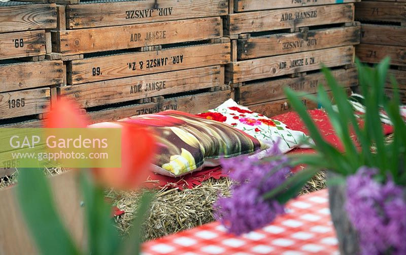 Pillows with tulip prints on a bench of hay. De Tulperij: Dutch nursery of Daan and Anja Jansze at Voorhout, Holland.