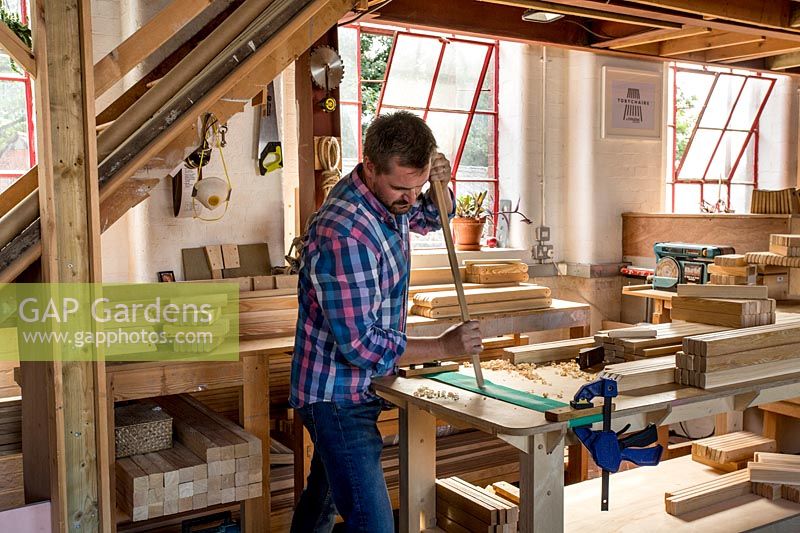 Chris Punch, garden furniture designer in workshop preparing wood