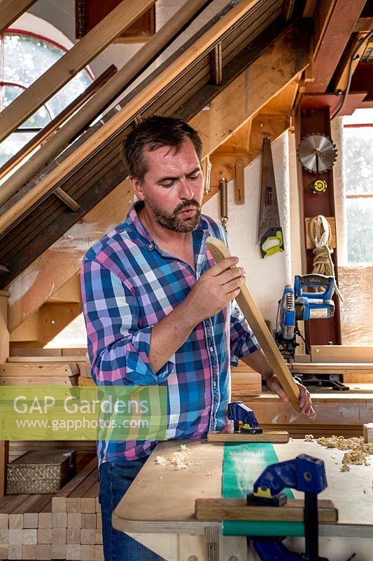 Chris Punch, garden furniture designer in his workshop preparing wood