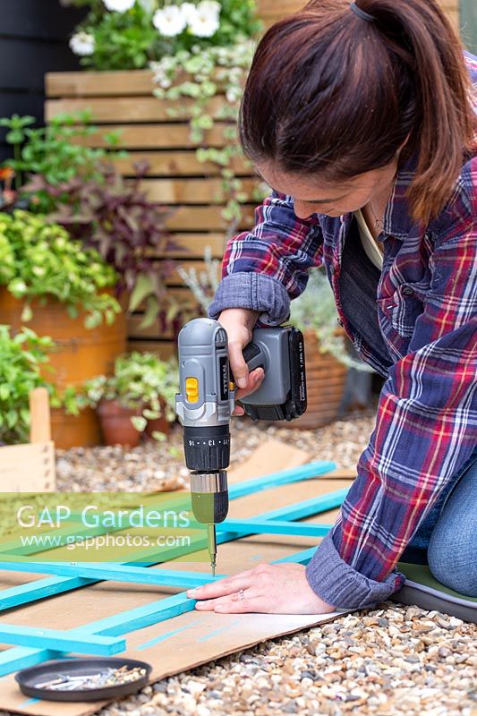 Fixing wooden strips together with screws and screwdriver