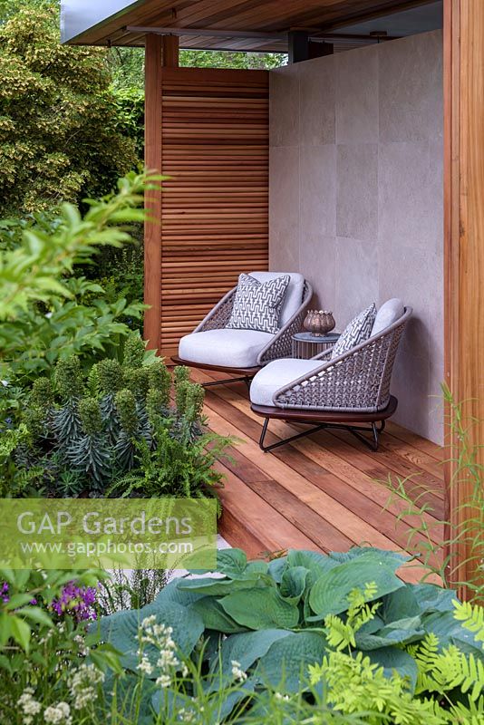 Armchairs on decking by pavilion - The Morgan Stanley Garden for the NSPCC - Sponsor: Morgan Stanley - RHS Chelsea Flower Show 2018