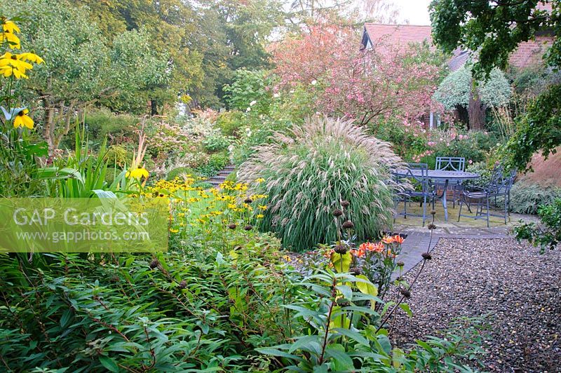 Mixed planting and garden seating area on patio, Shropshire, UK