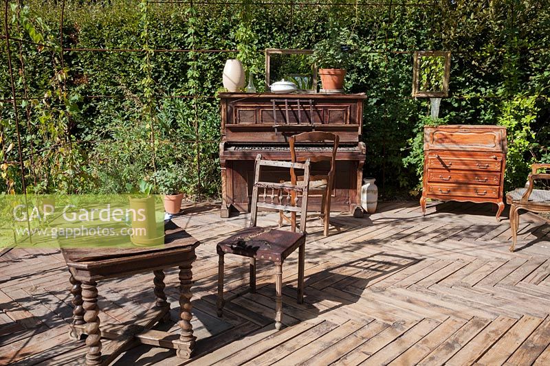 Old furniture, chairs, tables, dresser and piano, an allegory of Marcel 
Proust's life. Le Jardin de Proust. Proust's Garden.  Festival garden.
 Garden of Thought.  Festival des Jardins 2018, Chaumont sur Loire, France 