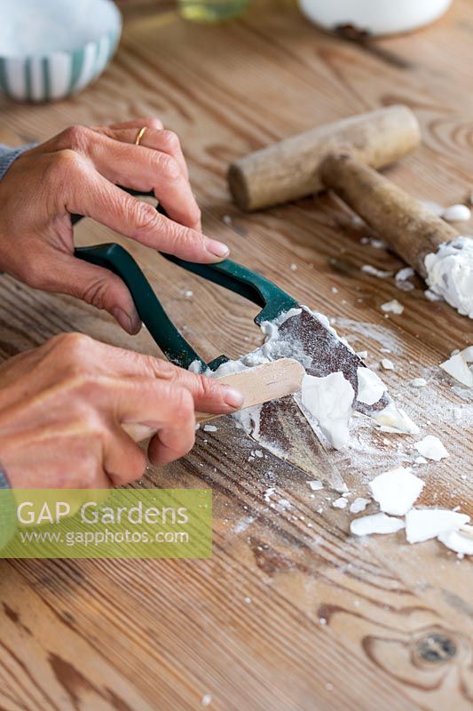 Removing the dry paste from the topiary shear with wooden spatula