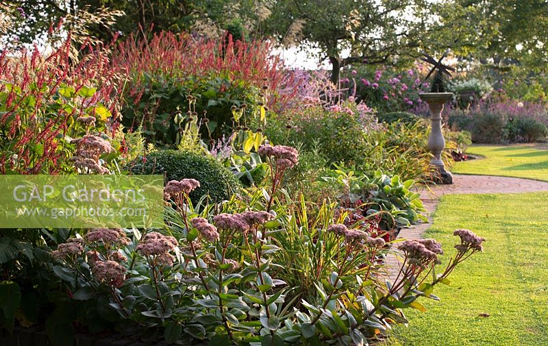 View along colourful flowering border in formal garden.