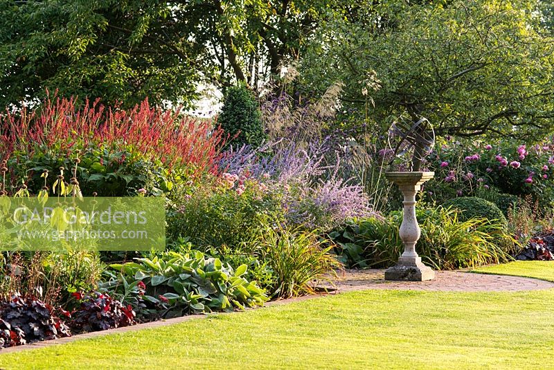 View along colourful flowering border in formal garden.