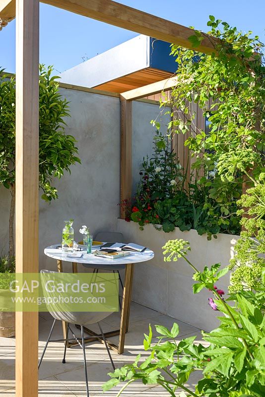 Wooden pergola with table and chair - 'The Urban Escape', RHS Malvern Spring Festival, 2018.