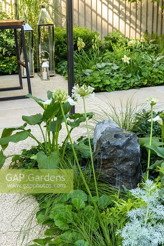 Shade planting - Agapanthus 'Albus', Zantedeschia and grasses with small water feature. 'Landform Garden Bar', RHS Hampton Flower Show, 2018