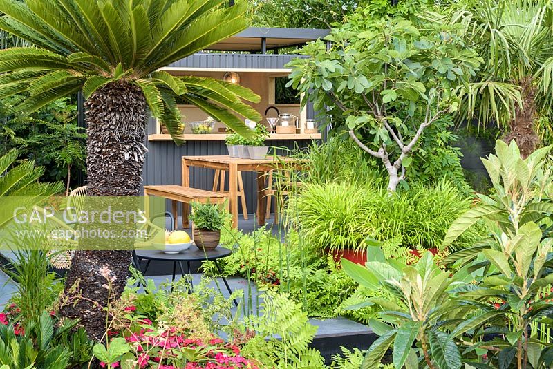 Metal shed and furniture. 'B and Q Bursting Busy Lizzie Garden' RHS Hampton Flower Show, 2018 