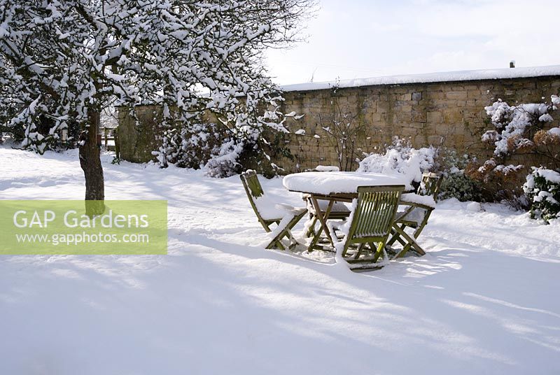 Teak table and chairs left out in heavy snow