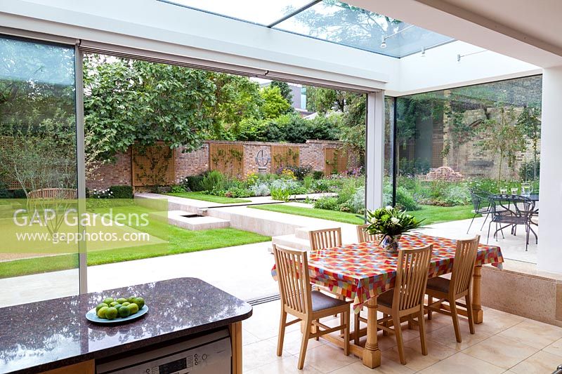 View from the dining room out to the patio and garden. Garden designed by Peter Reader Landscapes.