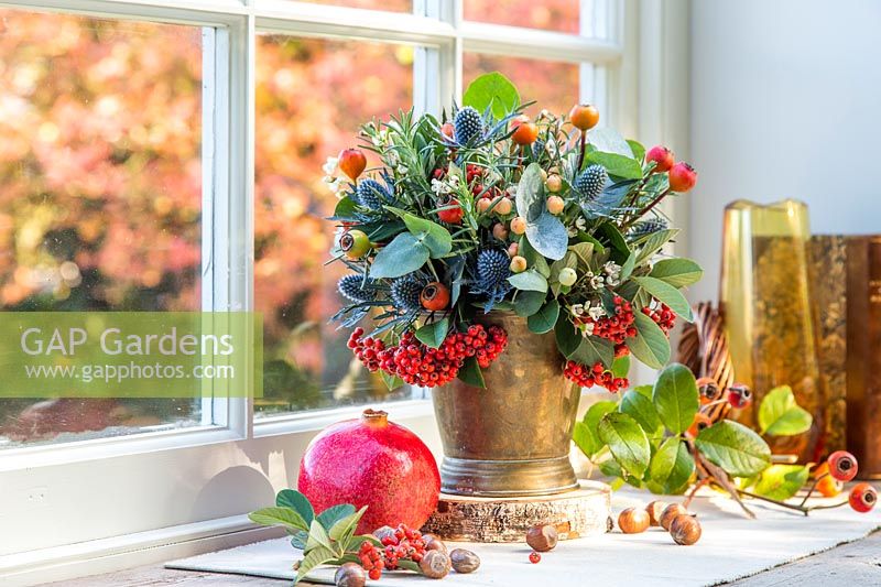 View of mixed festive floral arrangement on decorated windowsill.