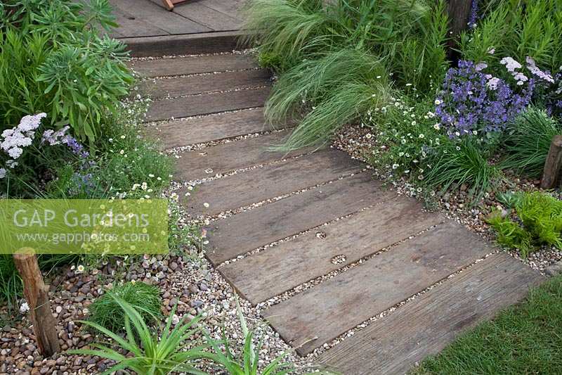 Railway sleeper path and coastal planting in Southend Council 'By The Sea' garden at RHS Hampton Court Flower Show, London, 2017.
