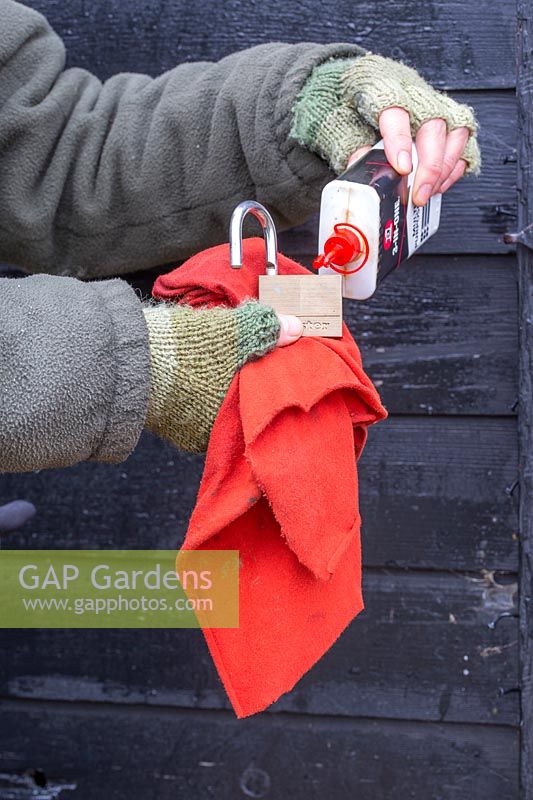 Woman oiling padlock. 