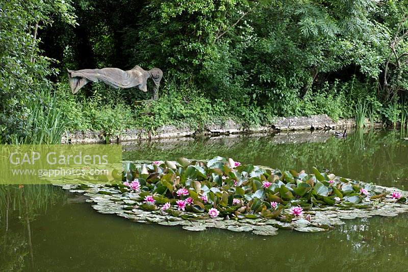 The 'Levitating Lady' made by Bloomsbury artist Quentin Bell, looks out across a pond with waterlilies.