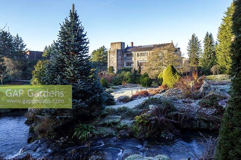 Stream running through rockery in frosty winter garden. Kilver Court, Somerset, UK. Designed by Roger Saul of Mulberry. 