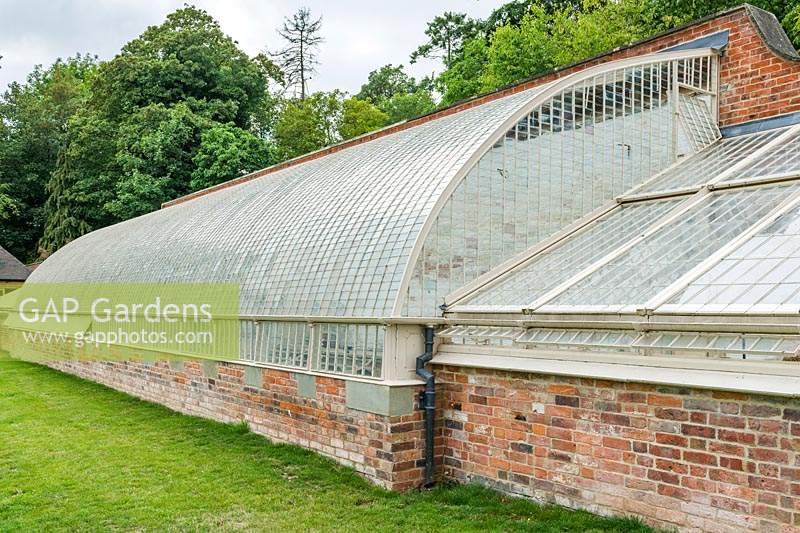 Restored iron-framed curvilinear glasshouses. Wildegoose Nursery, The Walled Garden, Lower Millichope, Munslow, Shropshire, UK. 