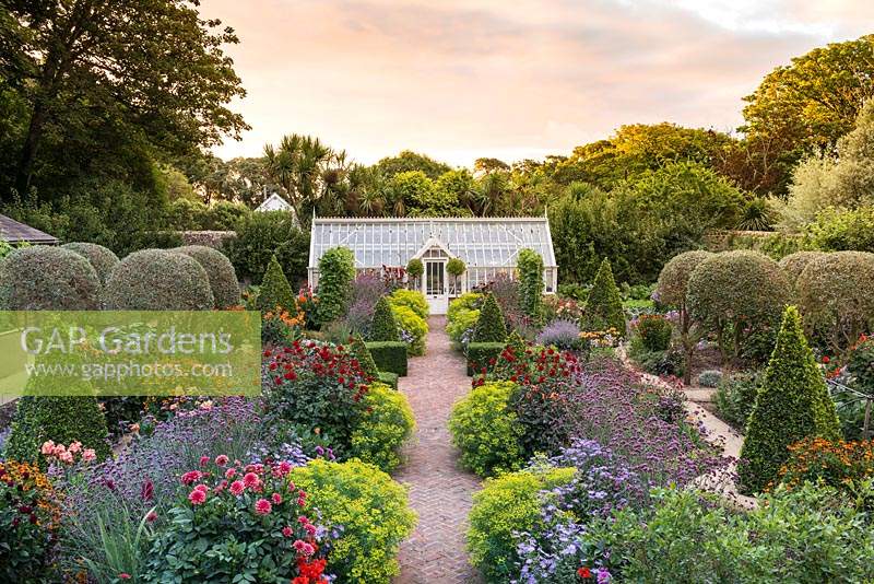 A fully restored Victorian walled kitchen garden is planted with a mix of topiary, annual flowers, herbs, fruits and vegetables.