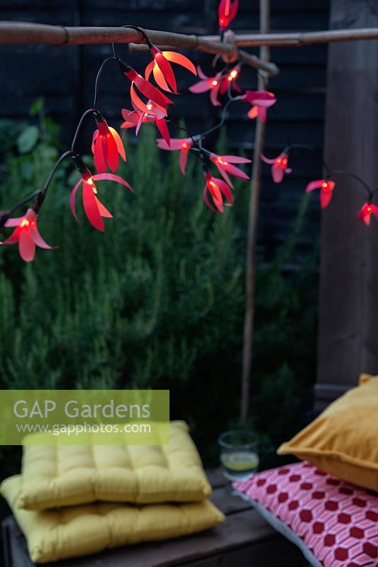 Fairylights decorated with colourful paper shapes create beautiful decorative outdoor lighting. 