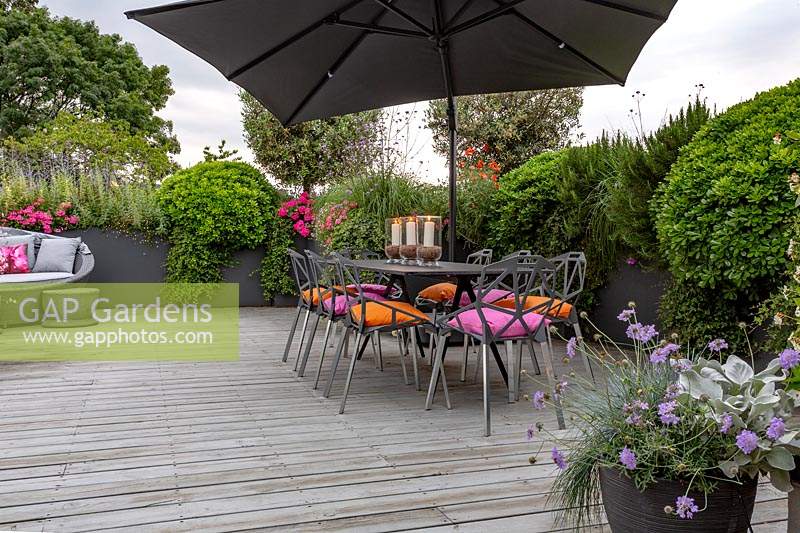 Roof garden with dining table and chairs.