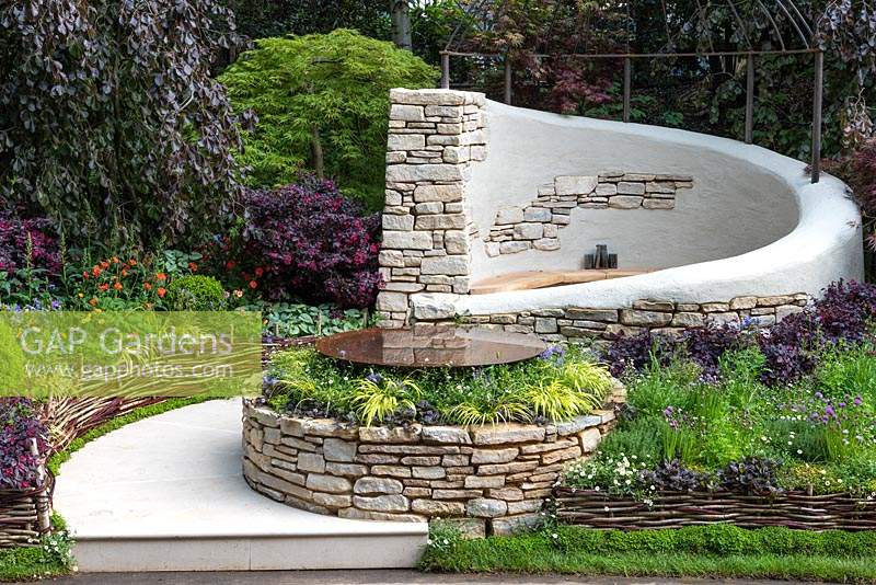 The Kingston Maurward Garden. A romantic curving seating area in Purbeck stone, enclosed in purple beeches, acers and herbaceous planting. Sponsors: Miles Brown, Kingston Maurward College, Goulds Garden Centre, Wilks Landscaping, Holme for Gardens, The Green Gardener.