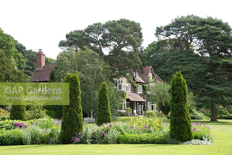 A view of Abbeywood House, an Edwardian residence built in 1908, seen accross a herbaceous border with prepeated conifers