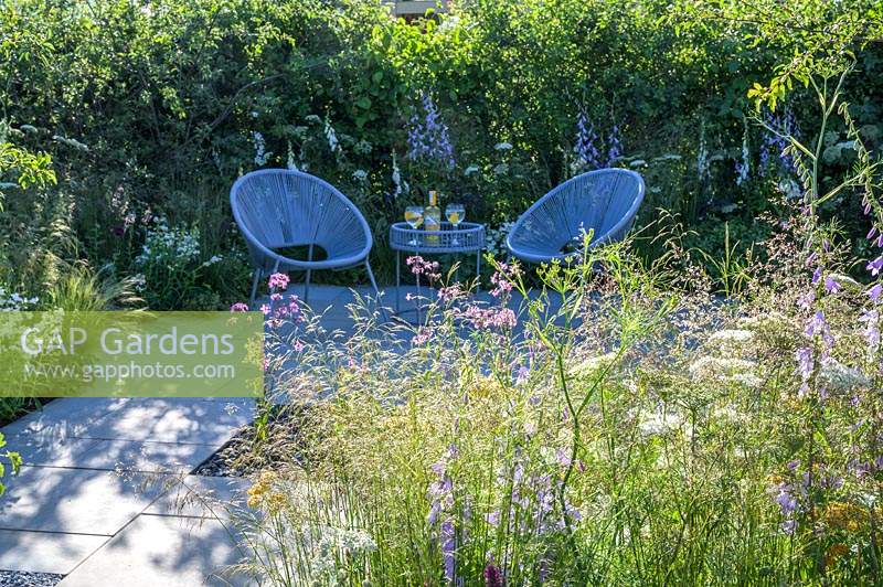 Seating area with two armchairs and planting of nectar-rich flowers - The Urban Pollinator Garden - RHS Hampton Court Palace Garden Festival, 2019 - Designer: Caitlin McLaughlin