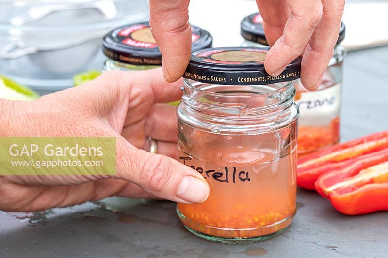 Woman adding lids to the jam jars