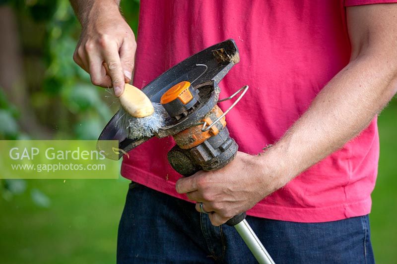 Cleaning a strimmer head with a hand brush