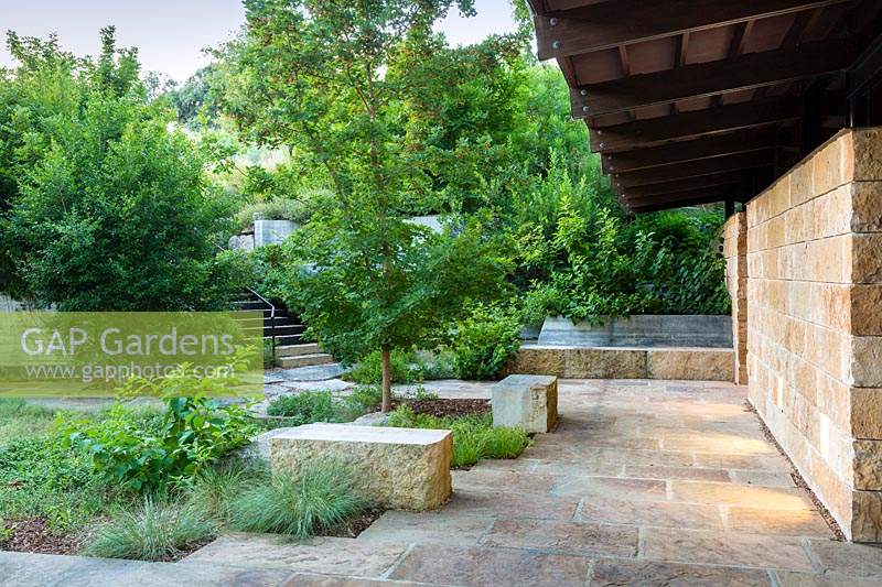 Paved area with seating and mixed planting at Mill Creek Ranch in Vanderpool, Texas designed by Ten Eyck Landscape Inc, July.