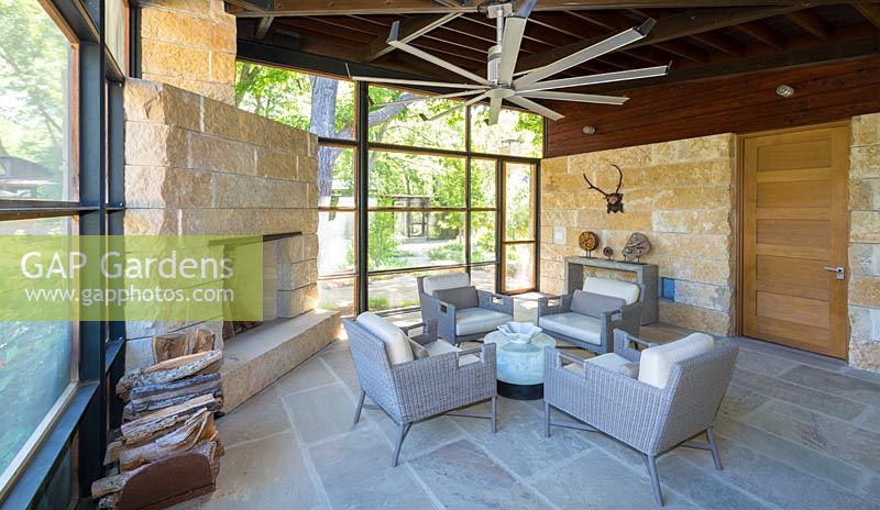 Limestone walls and stone paving inside modern living room at Mill Creek Ranch in Vanderpool, Texas designed by Ten Eyck Landscape Inc, July.