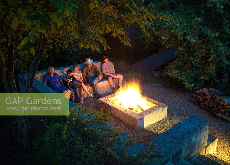 Family seated around the fire pit at Mill Creek Ranch Vanderpool, Texas designed by Ten Eyck Landscape Inc, July.