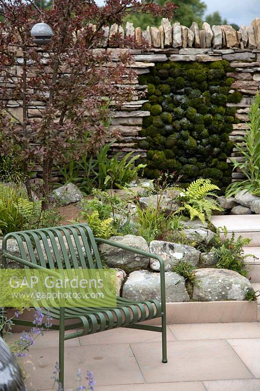 Dry stone wall with moss mounds in the 'Elements of Sheffield' garden at the RHS Chatsworth Flower Show 2019.