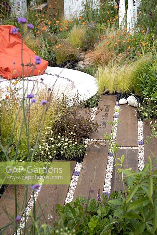 'Find Yourself Lost in the Moment' garden - RHS Chatsworth Flower Show 2019 - view of path showing mixed materials.