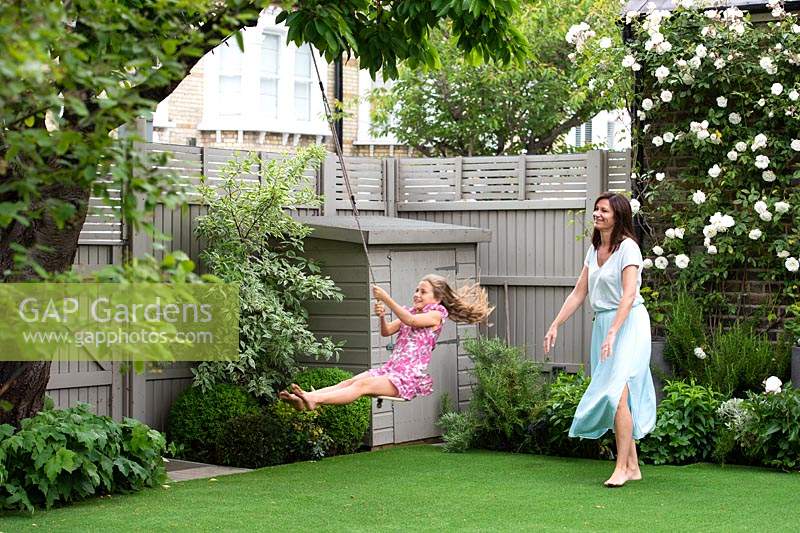 The garden owner Anne playing with her daughter in the garden. 