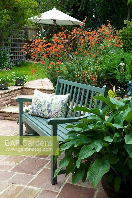 Turquoise bench on patio in front of orange Geum and beside container-grown Hosta - Open Gardens Day 2015, Drinkstone, Suffolk